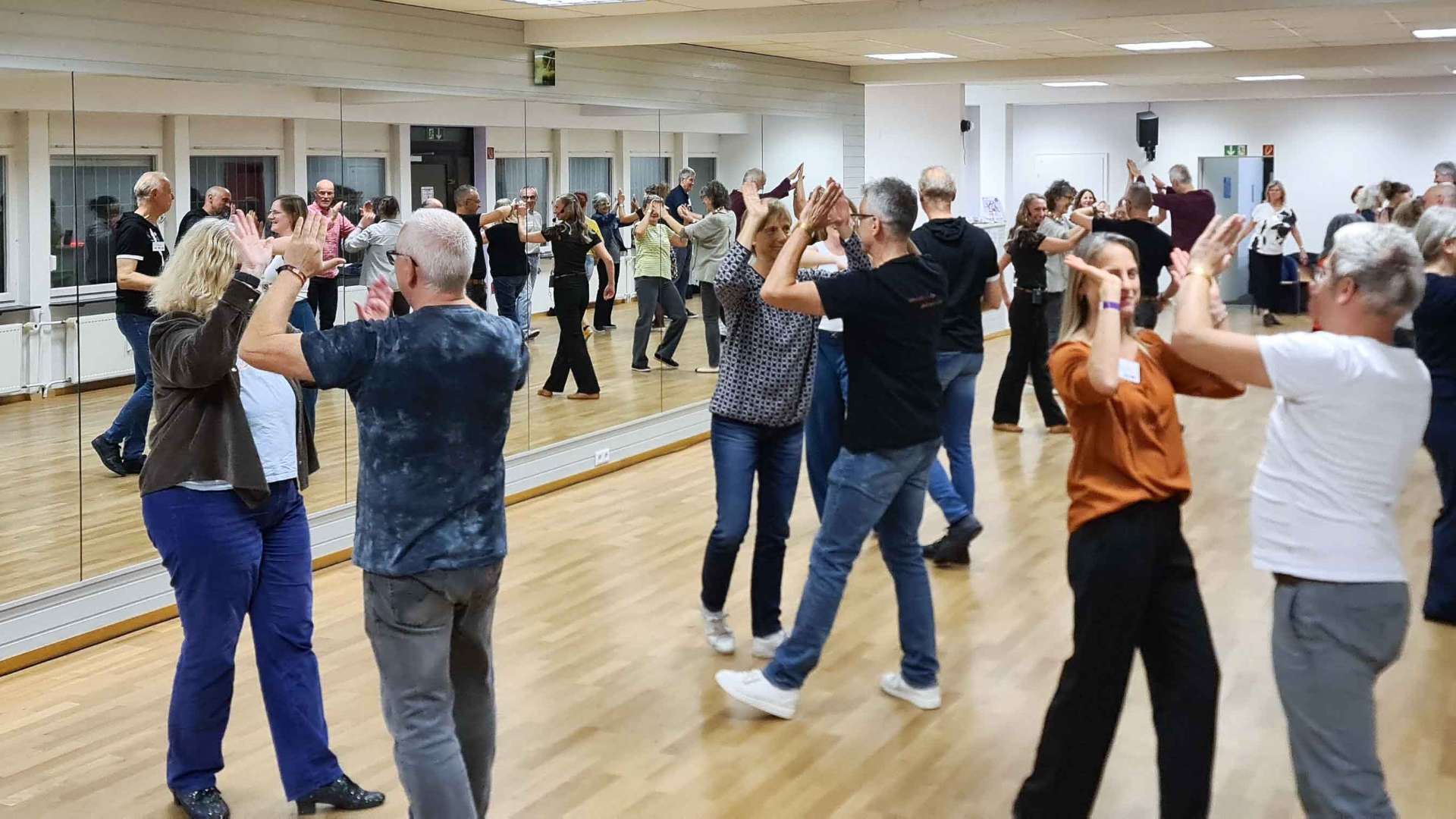 Gruppe tanzt West Coast Swing im Saal